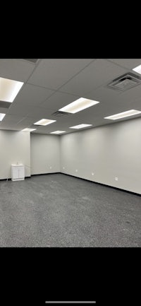 an empty room with gray walls and lights