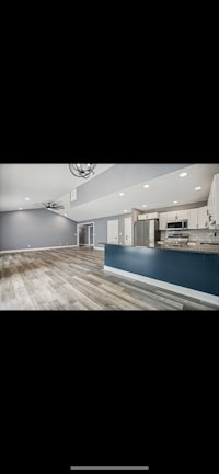 an image of a kitchen with wood floors and blue walls