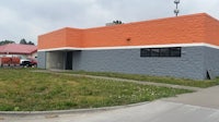 an orange and white building with a grassy yard