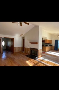 an empty living room with wood floors and a fireplace