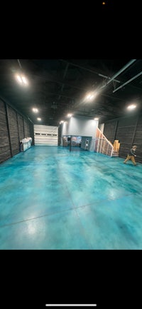 an empty garage with blue paint on the floor