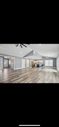 a large living room with hardwood floors and a ceiling fan